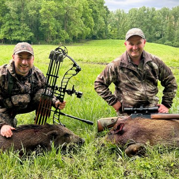 Deux chasseurs posant avec leurs sangliers après une matinée d'affût réussie