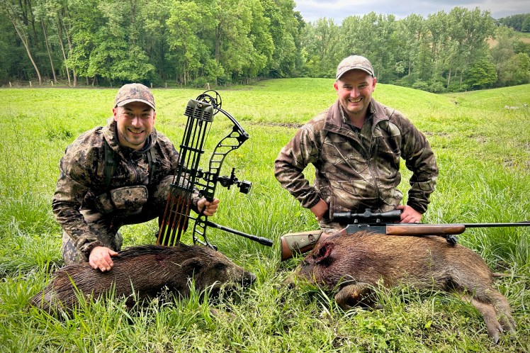 Deux chasseurs posant avec leurs sangliers après une matinée d'affût réussie