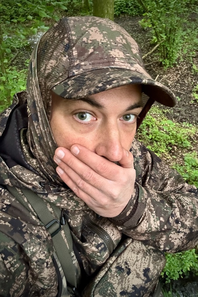 Chasseur à l'arc camouflé dans son treestand pendant un affût matinal