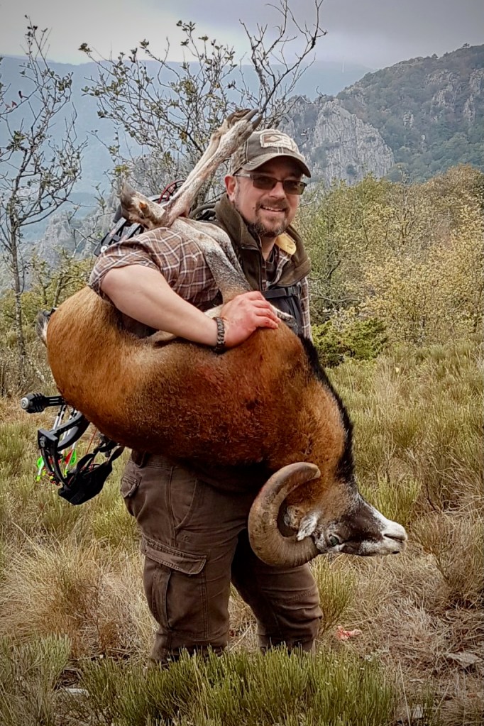 Laurent Duvivier portant un mouflon après une chasse en montagne