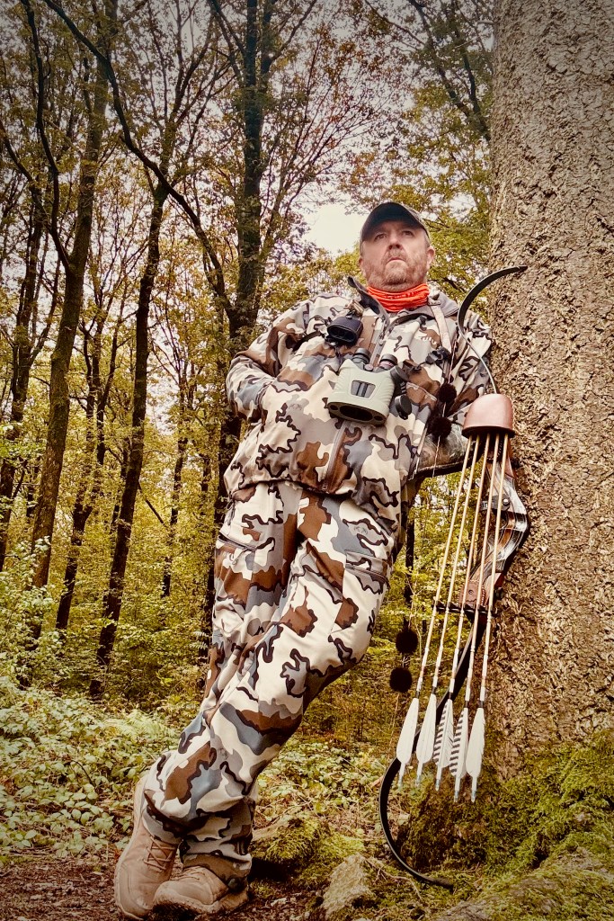 Jean Galoppin avec son arc dans une forêt